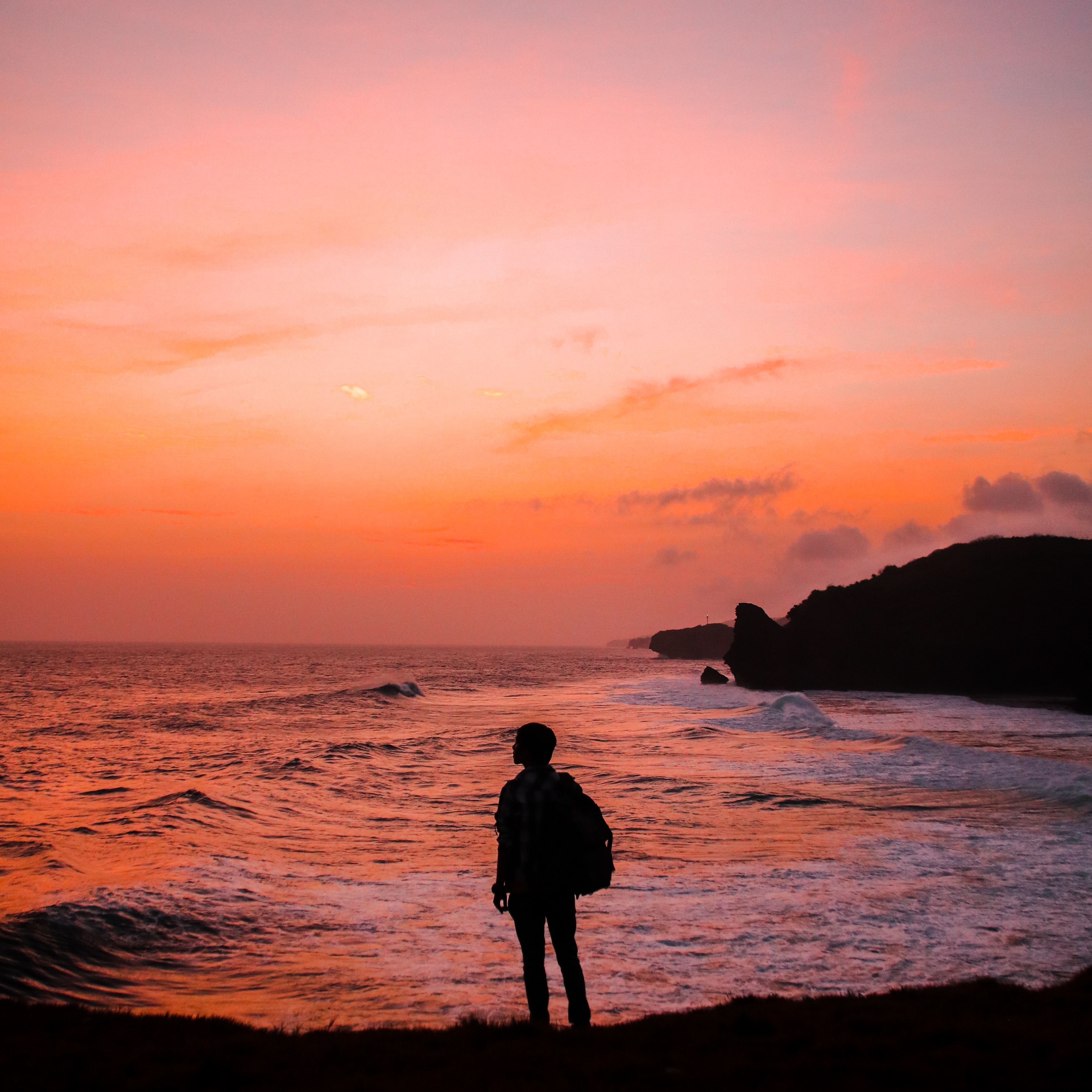 silhouette photo of man with backpack standing in seashore 848573
