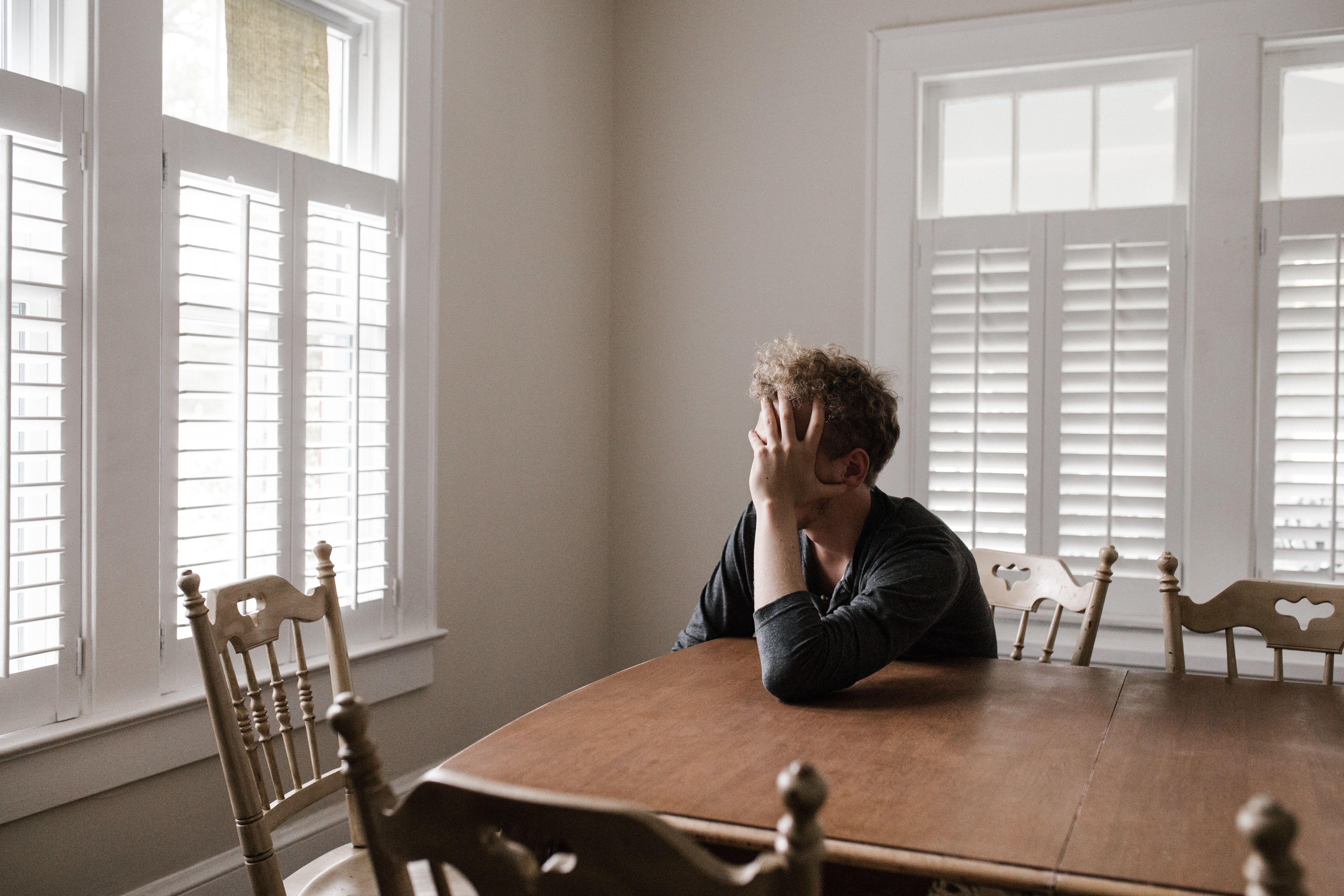 photo of man leaning on wooden table 3132388